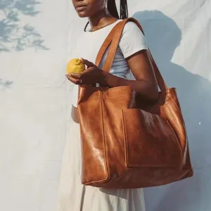 Bolso tote grande de cuero encerado marrón vintage con un práctico bolsillo delantero.
