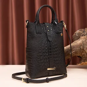 Vista detallada del bolso vintage negro con patrón de cocodrilo y bandolera