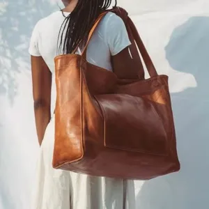 Bolso tote grande de cuero vintage con bolsillo exterior en ambiente soleado