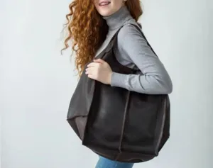 Vista detallada del bolso tote de cuero vintage marrón oscuro que lleva la modelo