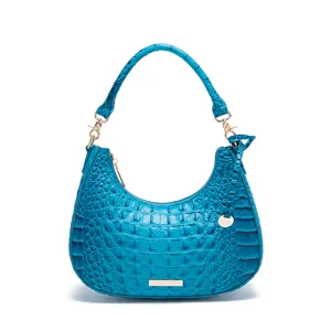 Dettaglio borsa hobo turchese effetto coccodrillo con eleganti finiture dorate.