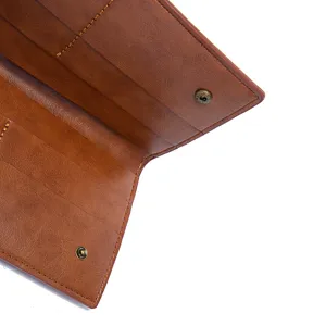 Close-up of brown vintage leather bag interior showing snap button and card slots