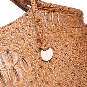 Primer plano de la textura grabada con patrón de cocodrilo en bolso retro de cuero marrón