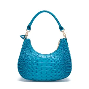 Dettaglio macro della borsa hobo blu turchese con motivo a coccodrillo in rilievo