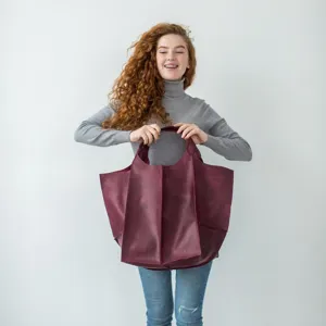 Mujer con un gran bolso tote burdeos de cuero encerado al aceite de estilo retro chic