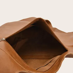 Vista detallada del espacioso interior de la mochila de cuero marrón con bolsillos