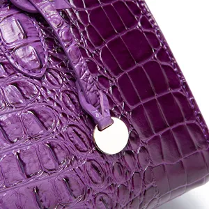 Primer plano de la textura de piel de cocodrilo morada en un bolso vintage de mujer