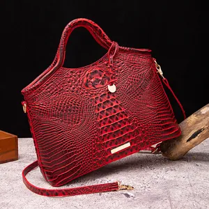 Vista detallada de un bolso de mano rojo con relieve de cocodrilo de estilo retro