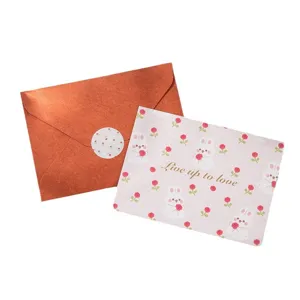 Linda tarjeta de felicitación con conejos y flores, texto dorado y sobre naranja