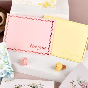 Vista detallada de elegantes tarjetas de felicitación con letras doradas 'For you' en relieve