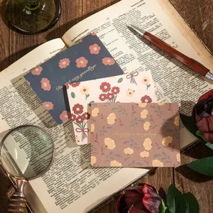 Primer plano de tarjetas de felicitación florales vintage con estampado dorado en un libro antiguo