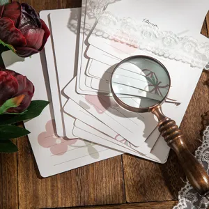 Primer plano de tarjetas de felicitación florales vintage con texto 'Dear' y lupa