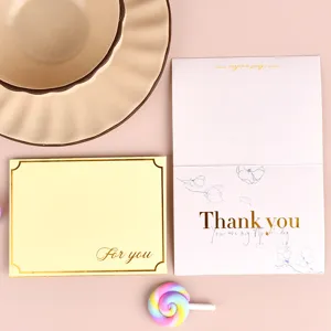 Vista detallada de tarjetas de agradecimiento y felicitación con lámina dorada