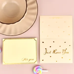 Detalle de tarjeta de felicitación con pan de oro, mensaje Just Love You y corazones