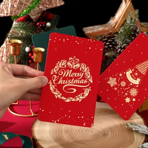 Mano sosteniendo una tarjeta de Navidad retro roja con diseño dorado de Merry Christmas
