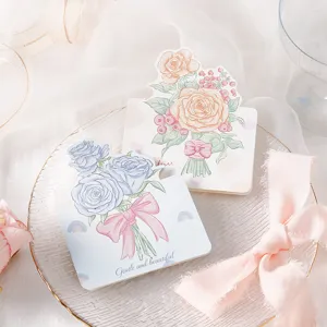 Close-up of hand-painted floral greeting cards with rose illustrations and ribbon