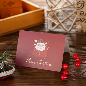 Detailed view of a burgundy Christmas card with gold foil Santa Claus illustration.