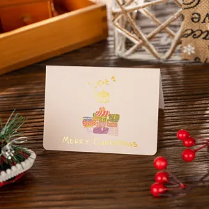 Detail shot of a small Christmas card featuring gold foil stamping and gift icons