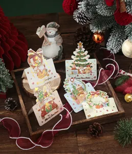 Close-up of elegant gold-stamped Christmas cards with festive holiday designs in a tray