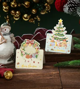 Detailed macro shot of festive gold foil Christmas cards featuring tree and wreath motifs