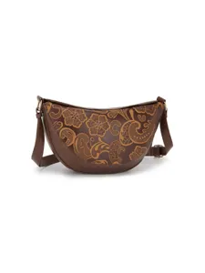 Primer plano de bolso de media luna marrón retro con elegantes flores grabadas