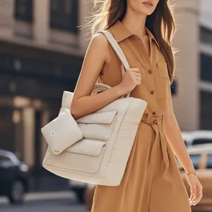 Stijlvolle beige gewatteerde puffer draagtas met kleine tas gedragen door model in stad