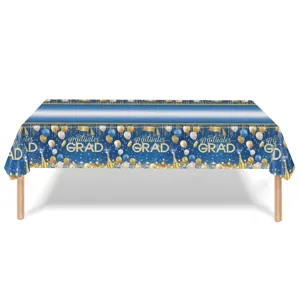 Gros plan d'une nappe de remise des diplômes bleu et or avec texte 'graduates GRAD' et ballons.