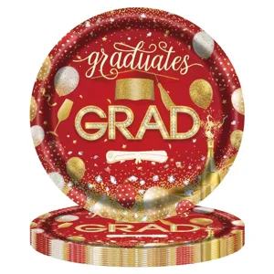 Détail d'assiettes en papier rouges de remise de diplôme avec motif de toque dorée