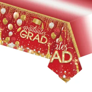 Gros plan de la nappe jetable en PE rouge et or avec imprimé GRAD pour fête de remise des diplômes