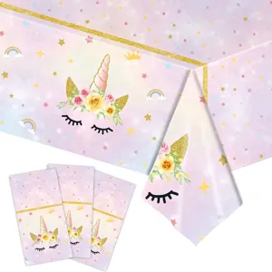 Détail de la nappe et des serviettes de fête licorne avec étoiles arc-en-ciel et roses