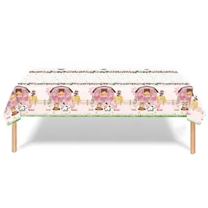 Nappe de fête rose sur le thème de la ferme avec illustrations de grange et vache.