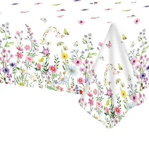 Gedetailleerd overzicht van kleurrijke lentebloemen en vlinders op wit tafelkleed