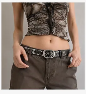 Détail d'une ceinture en cuir noir style punk avec des clous en métal argenté