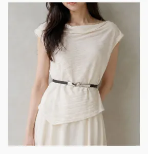 Detail of thin black belt with silver hook buckle on beige dress for women