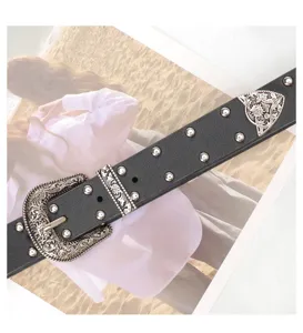 Detailed view of the vintage engraved silver buckle and studs on a black leather belt