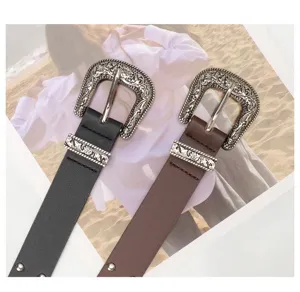 Close-up of retro Western belts featuring ornate silver engraved buckles and studs