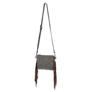 Vista detallada de bolso bandolera bohemio con grabado floral y flecos marrones.