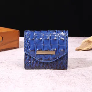 Vista detallada de una cartera para mujer azul con textura de cocodrilo vintage.