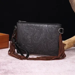 Detalle del bolso de cuero repujado bohemio con flecos marrones y patrón retro western.