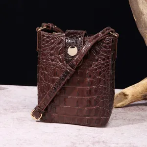Primer plano de bolso bandolera vintage marrón con textura de cocodrilo