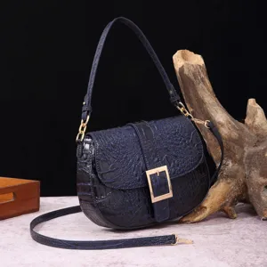 Vista detallada de un bolso baguette vintage azul oscuro con patrón de cocodrilo