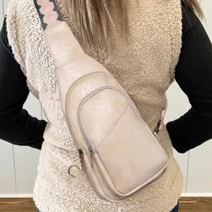 Vista trasera de un bolso bandolera beige para mujer con correa bohemia