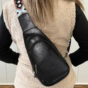 Vista detallada de bolso bandolera de cuero PU negro con correa boho de colores.