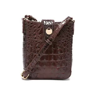 Vista detallada de un bolso bandolera retro para móvil con relieve de cocodrilo marrón.