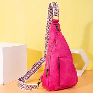 Detalle de bolso bandolera de cuero sintético rosa con correa tejida ancha