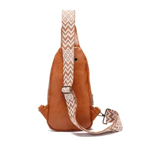 Detalle de bolso bandolera vintage marrón con correa bohemia y orificio para auriculares