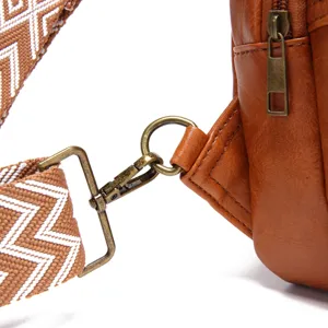 Detalle de un bolso de cuero marrón con correa bohemia y herrajes de bronce antiguo
