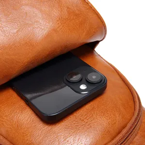 Primer plano del amplio bolsillo delantero de un bolso de pecho de cuero marrón