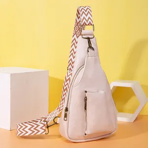 Detalle de bolso bandolera boho beige con una correa ancha con diseño de zigzag
