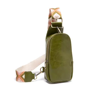 Detalle del bolso bandolera vintage de cuero verde con una correa tejida ancha estilo bohemio
